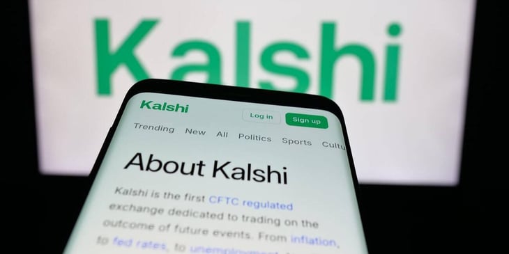 Mobile phone with website of US prediction market Kalshi Inc. in front of blurred background of Kalshi logo