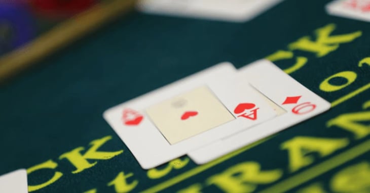 A pair of cards sit on a casino game table